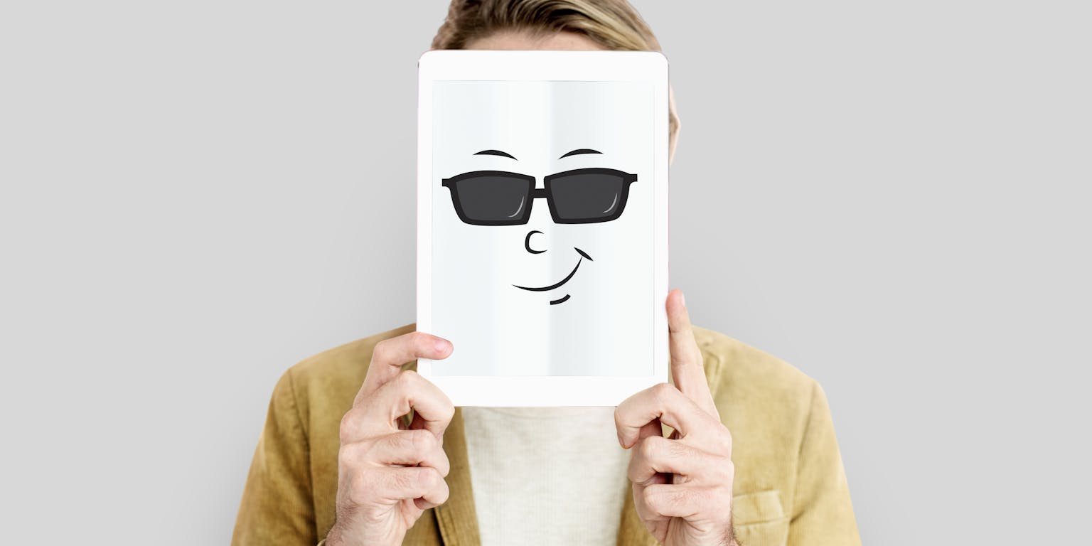 Man houdt een papier voor zijn gezicht met daarop een getekend gezicht met een zonnebril en een lach