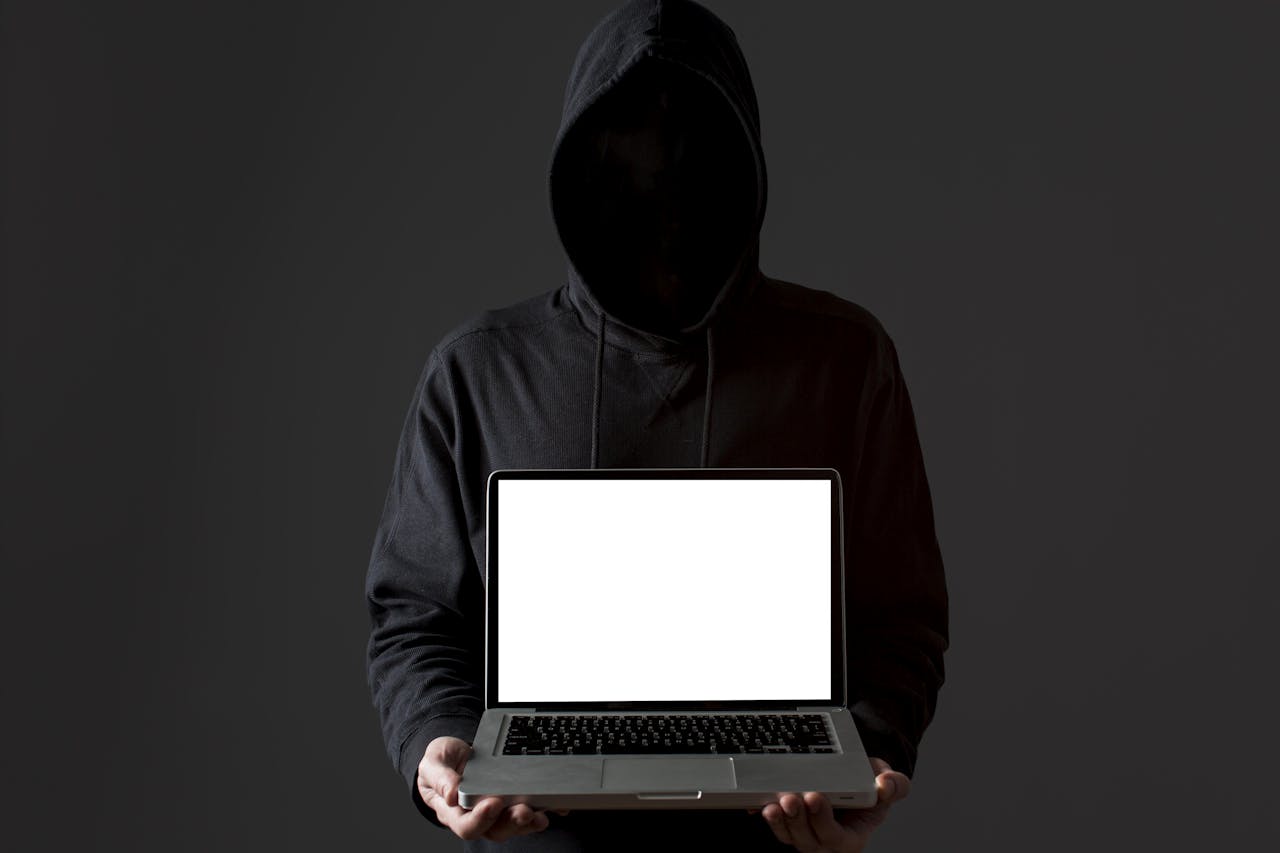Het stelen van data is een vrij technisch verhaal. Een man of vrouw met een hoody in een slecht verlichte kamer houdt een hel verlichte laptop voor zijn borst