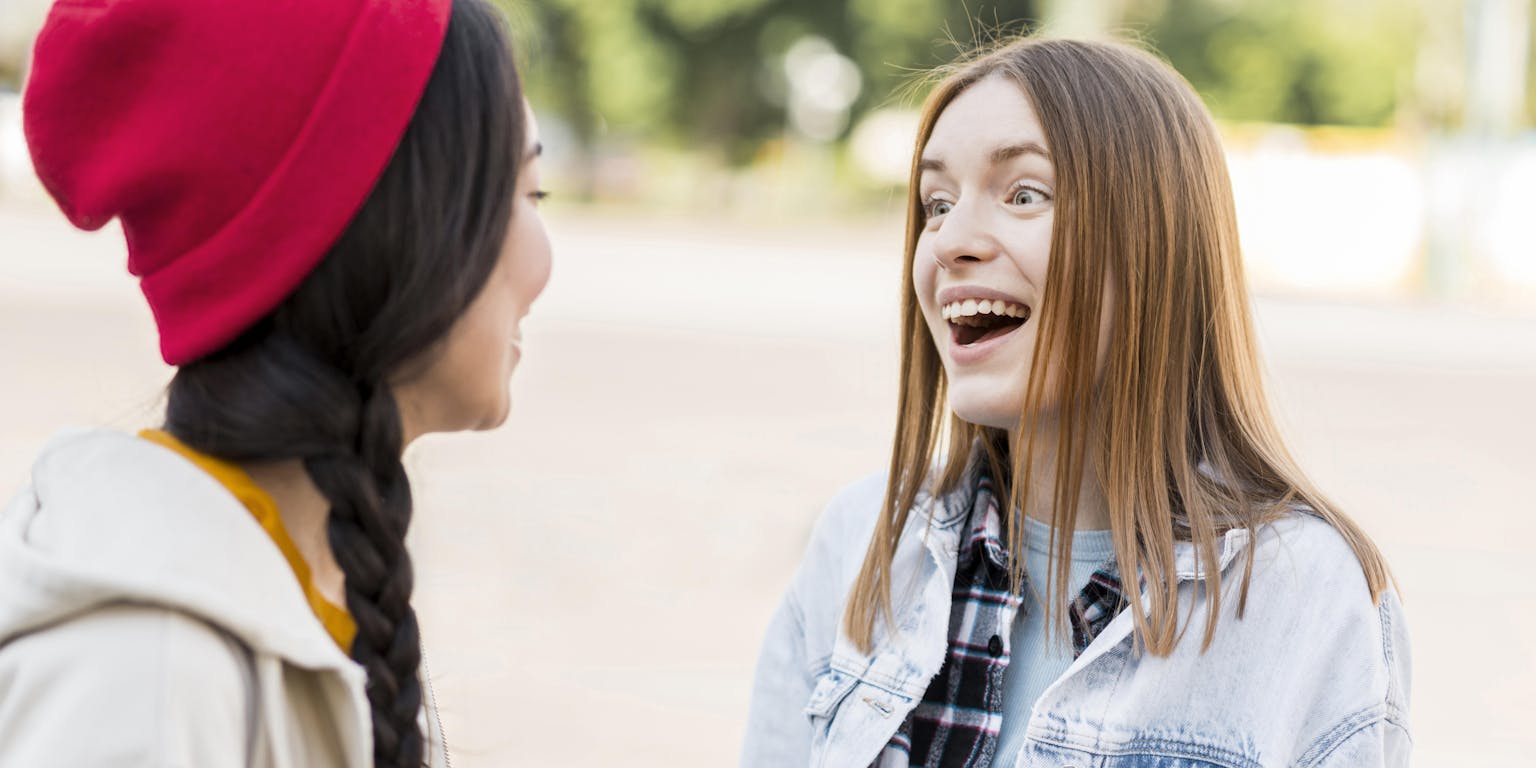 twee jonge vrouwen praten enthousiast met elkaar
