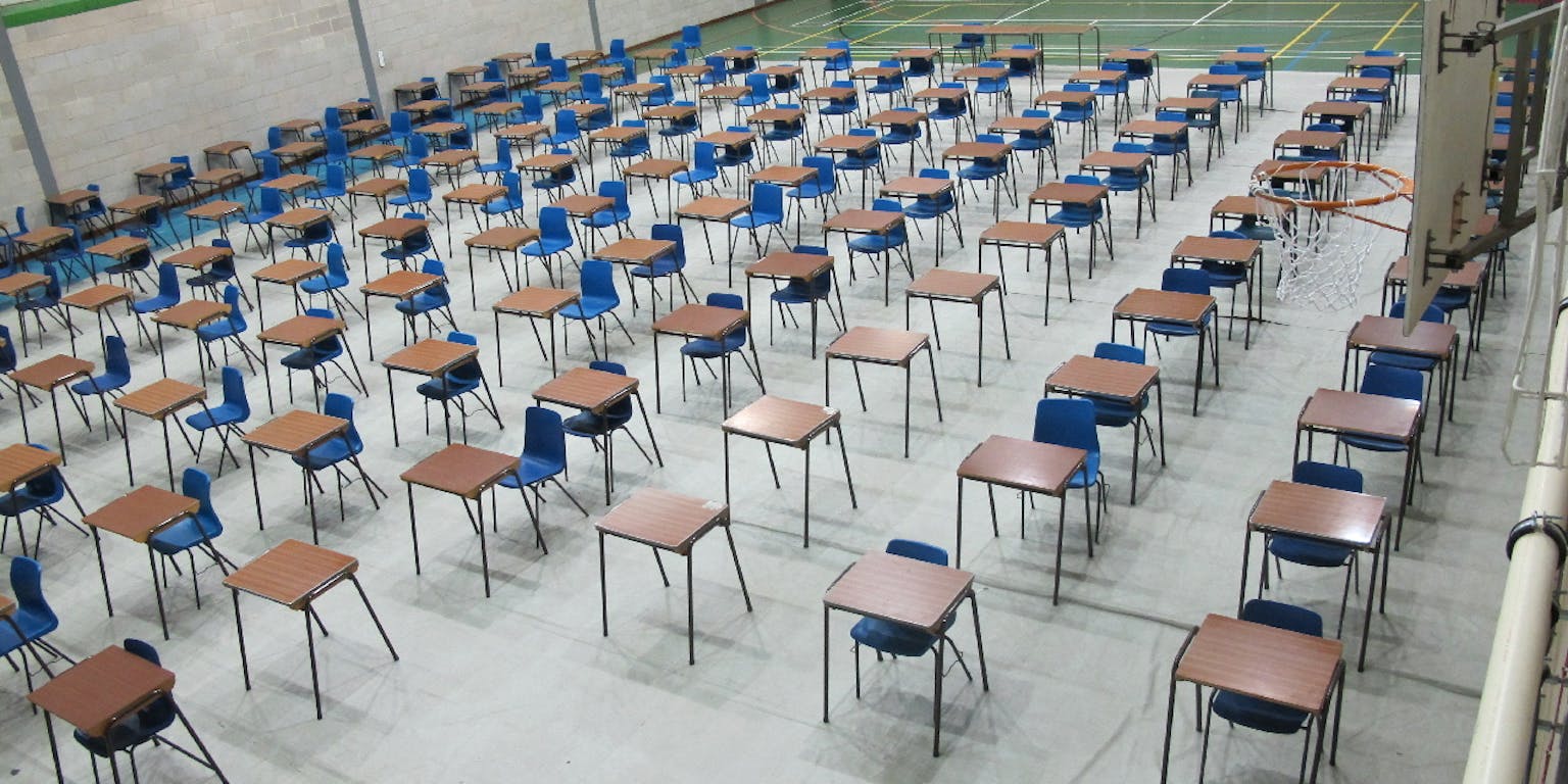 Een gymzaal vol met bureaus en stoelen