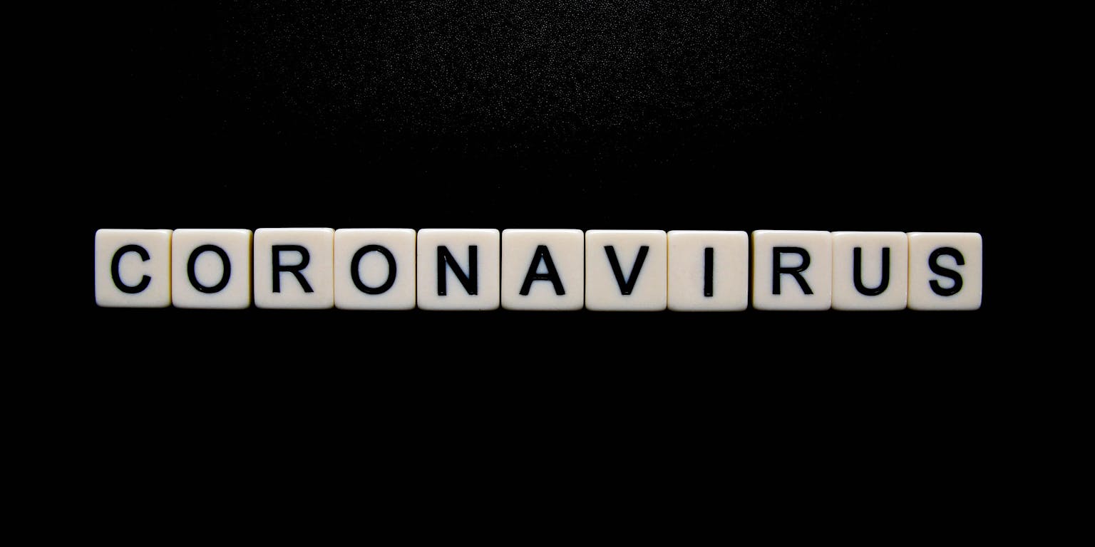 Het woord coronavirus gespeld op een zwarte achtergrond.