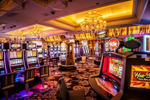 Met felle kleuren en veel geluid wordt constant de aandacht van gokkers getrokken om nog meer geld uit te geven. Een rijtje gokmachines in een casino