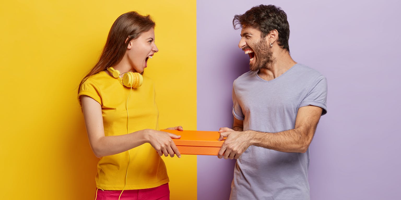 man en vrouw trekken samen aan een doos omdat ze niet willen delen