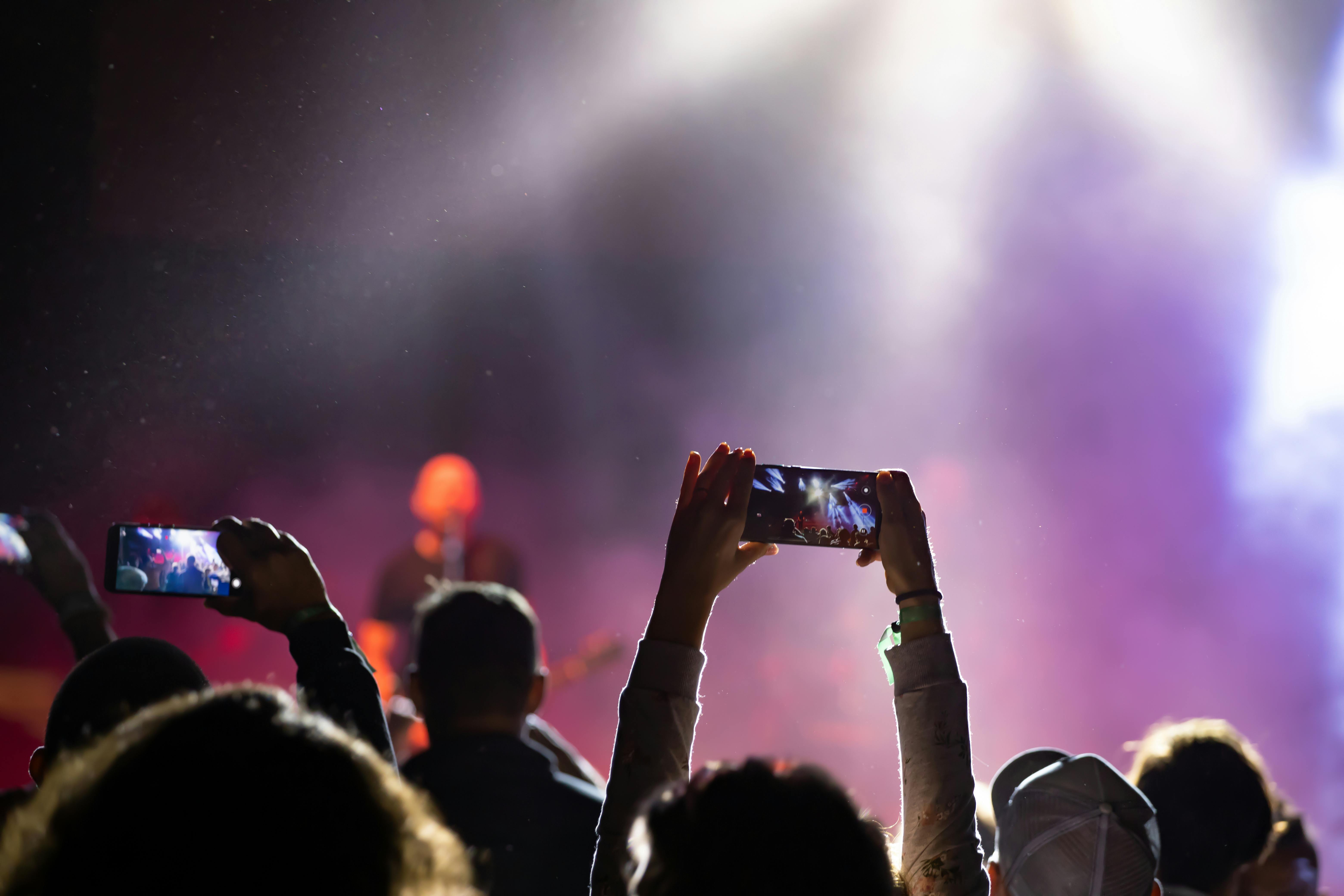 mensen maken foto's tijdens muziekconcert