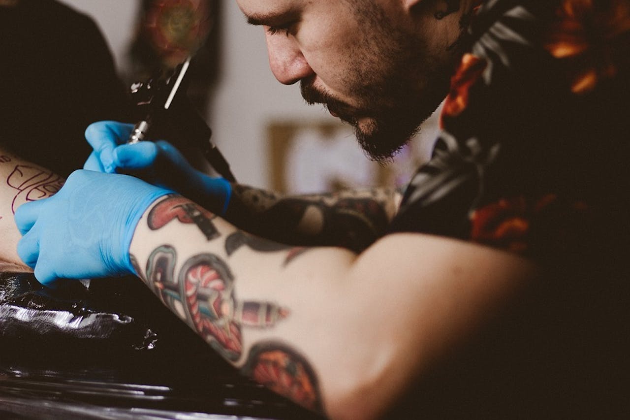 Een man zet een tatoeage zetten in een tattooshop.