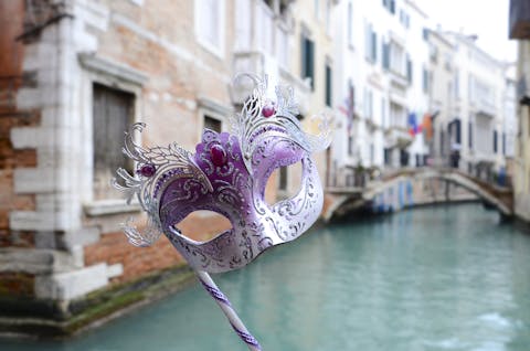 Het hoogtepunt deze zomer was de opera Cavalleria Rusticana op het San Marcoplein in Venetië. kleurrijk venetiaans masker bij achtergrond met water en gebouwen in Venetie