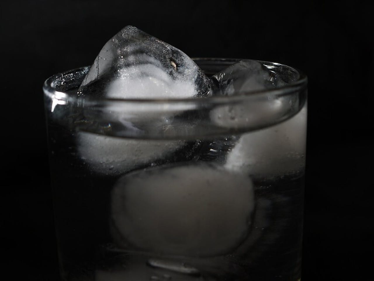 Een glas water met ijsblokjes erin.