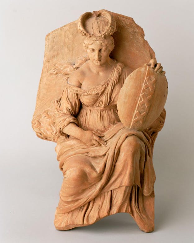 Een kleimodel van de maagd van Amsterdam op het Paleis op de Dam. Het kleimodel laat een zittende vrouw zien, met op haar knie het schild van de stad Amsterdam. Een kleimodel van de maagd van Amsterdam op het Paleis op de Dam. Het kleimodel laat een zittende vrouw zien, met op haar knie het schild van de stad Amsterdam.