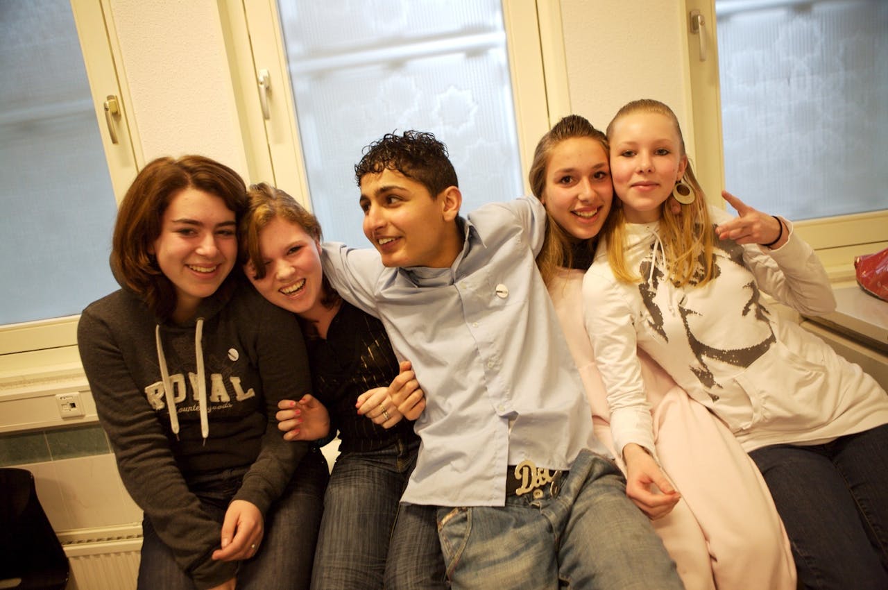 Ze zijn er natuurlijk wel: interetnische vriendschappen in de klas. Maar de kans daarop is wat kleiner dan vriendschappen tussen leerlingen van gelijke afkomst. Een groep jongeren poseert voor een foto.