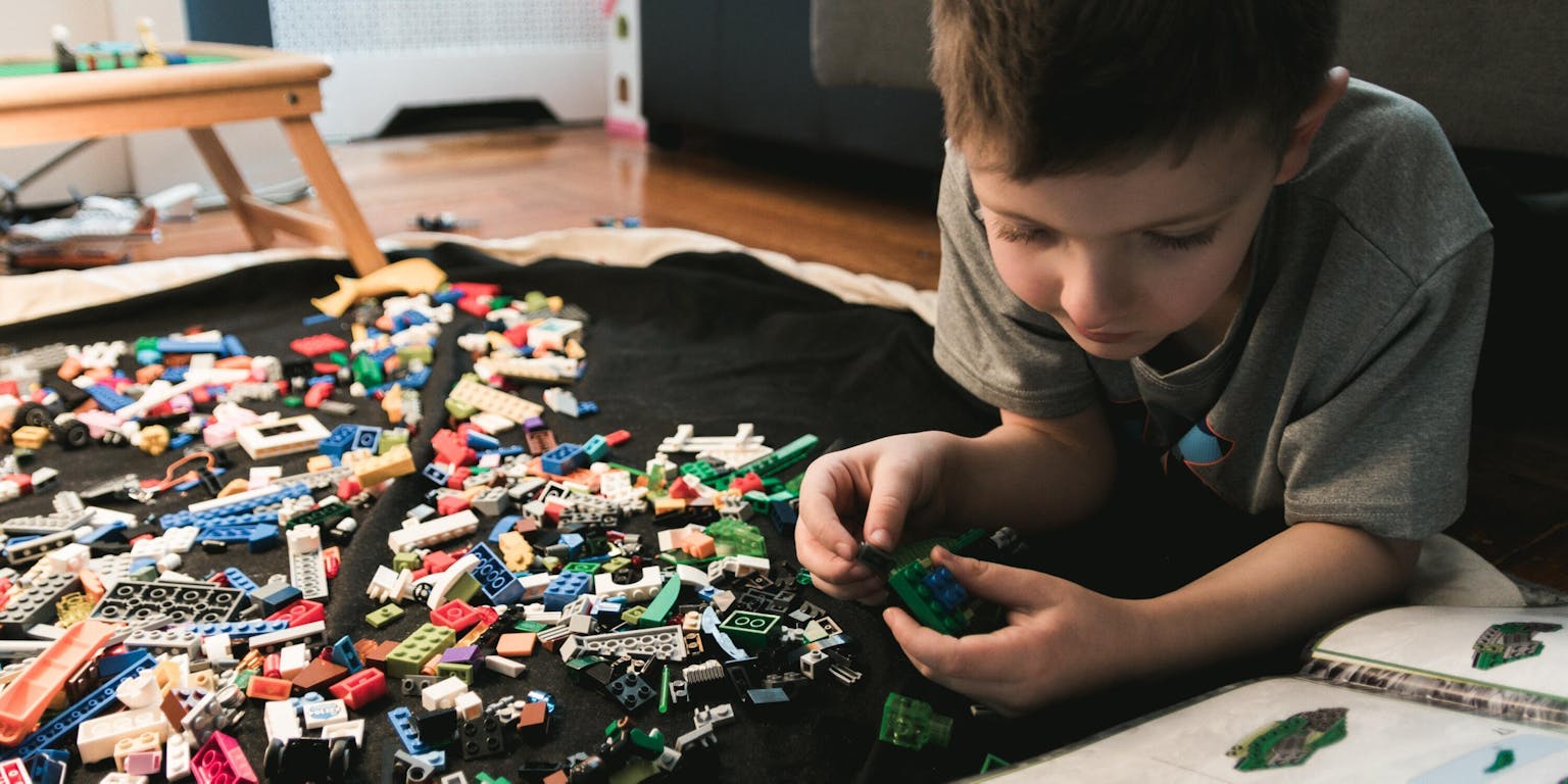 Een kind speelt met Lego.