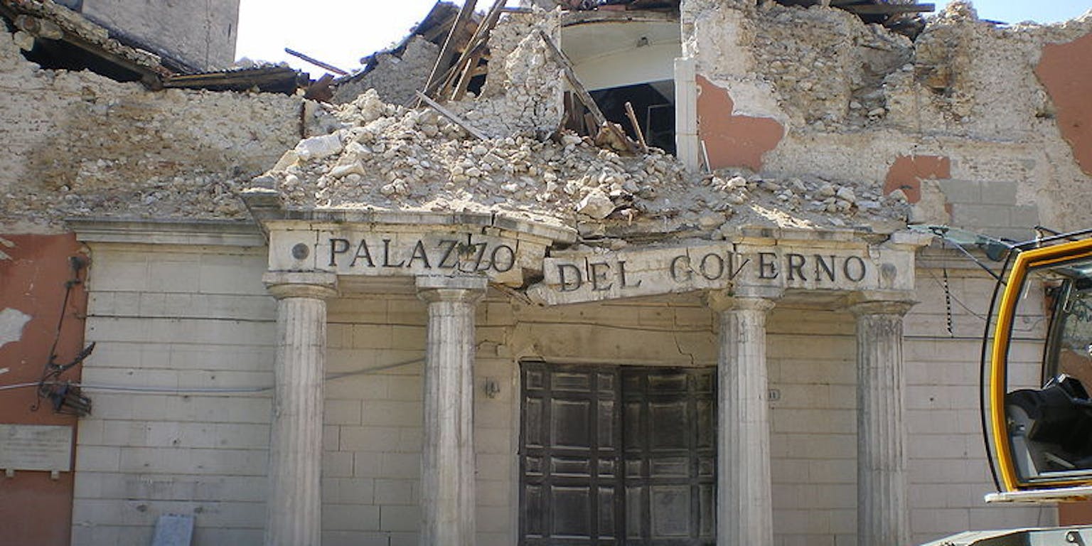 Een bulldozer staat voor ingestort Kloostergebouw Palazzo del Governo.