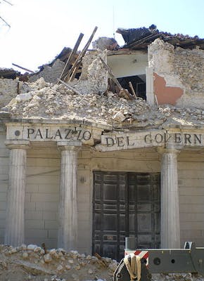Een bulldozer staat voor ingestort Kloostergebouw Palazzo del Governo.