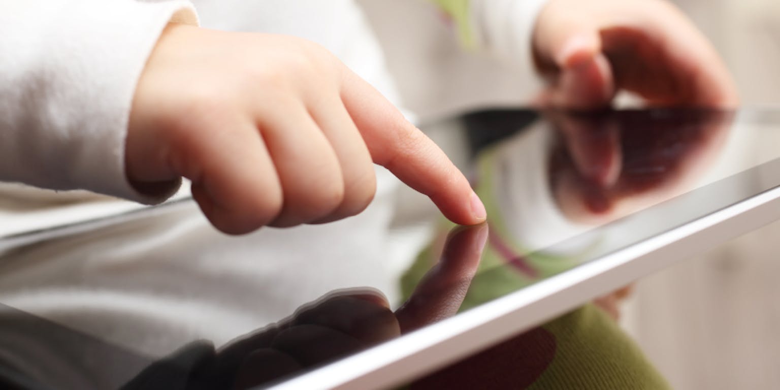 Een kind gebruikt een tablet.