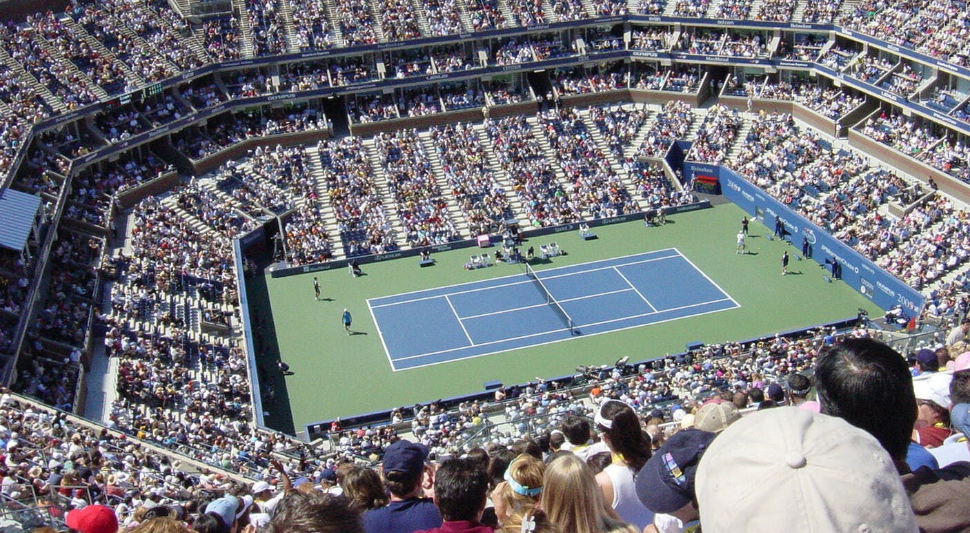 Een menigte mensen die naar een tenniswedstrijd kijken.