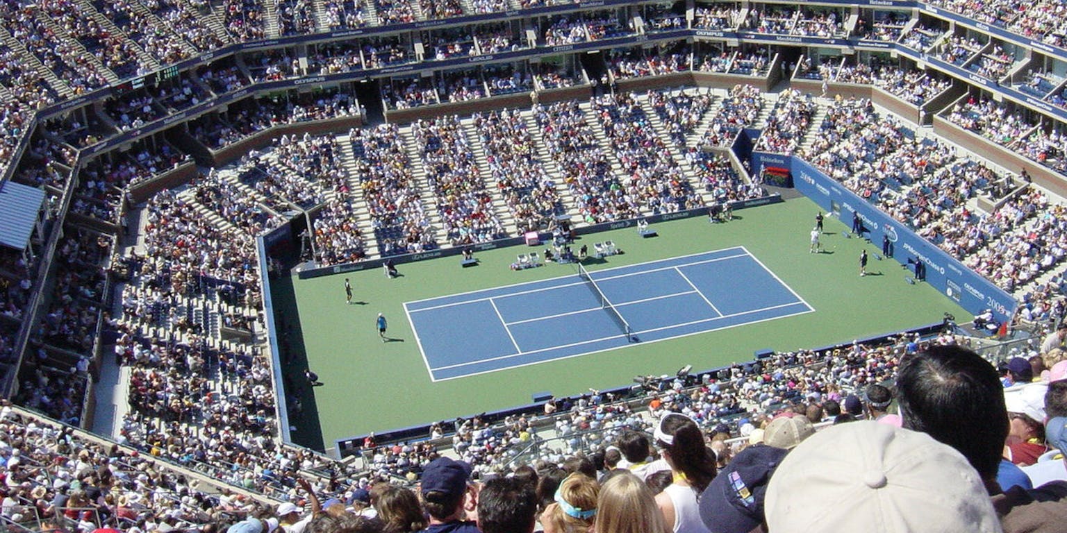Een menigte mensen die naar een tenniswedstrijd kijken.