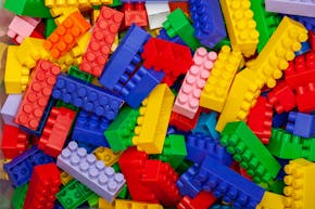 Berg van plastic bouwblokken in verschillende kleuren.