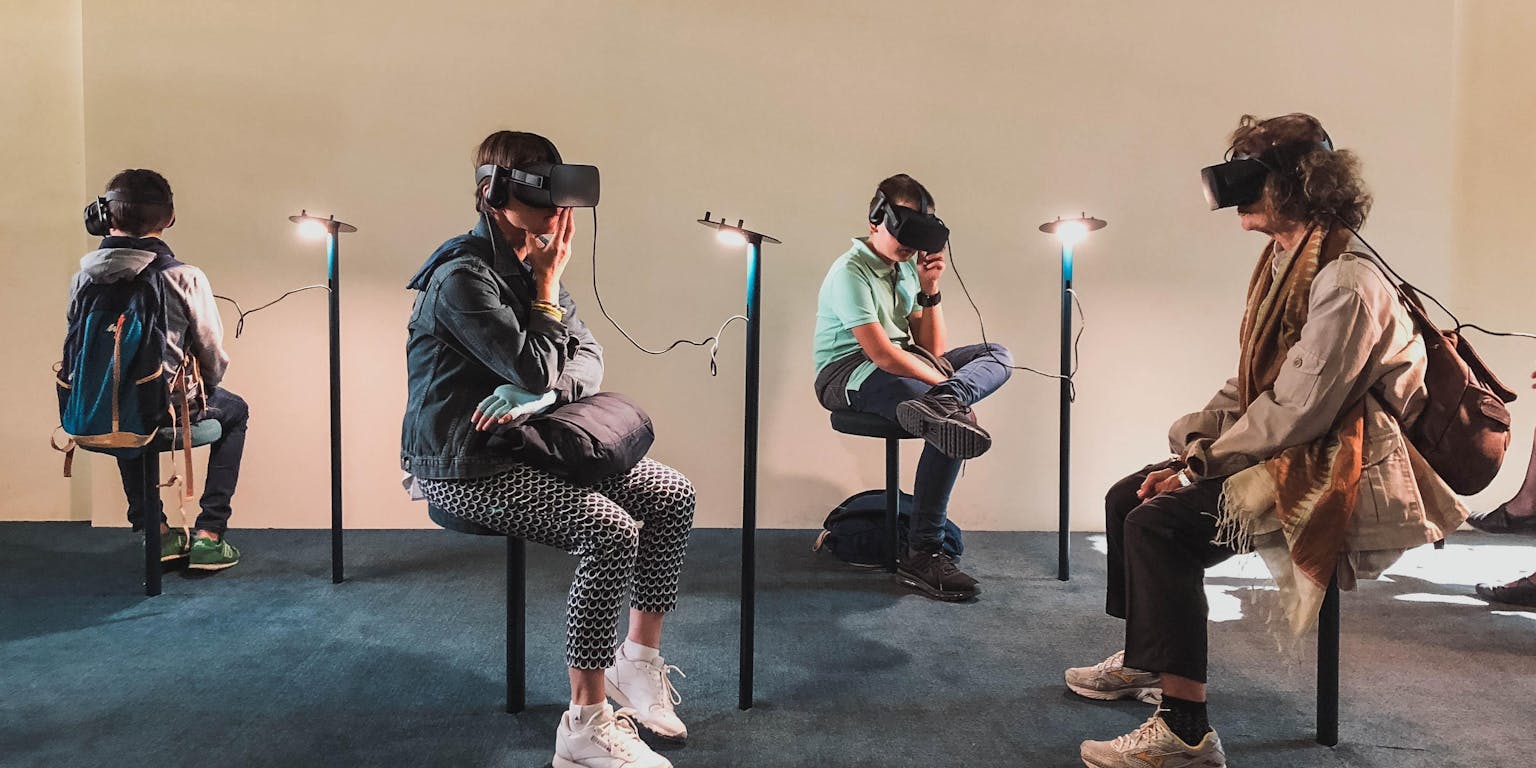 Een groep mensen zit in een kamer met VR-headsets.