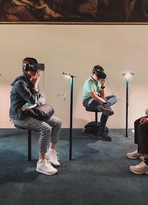 Een groep mensen zit in een kamer met VR-headsets.