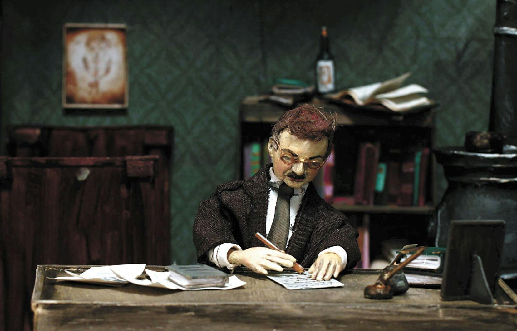 Een pop die aan een bureau zit met pen en papier.