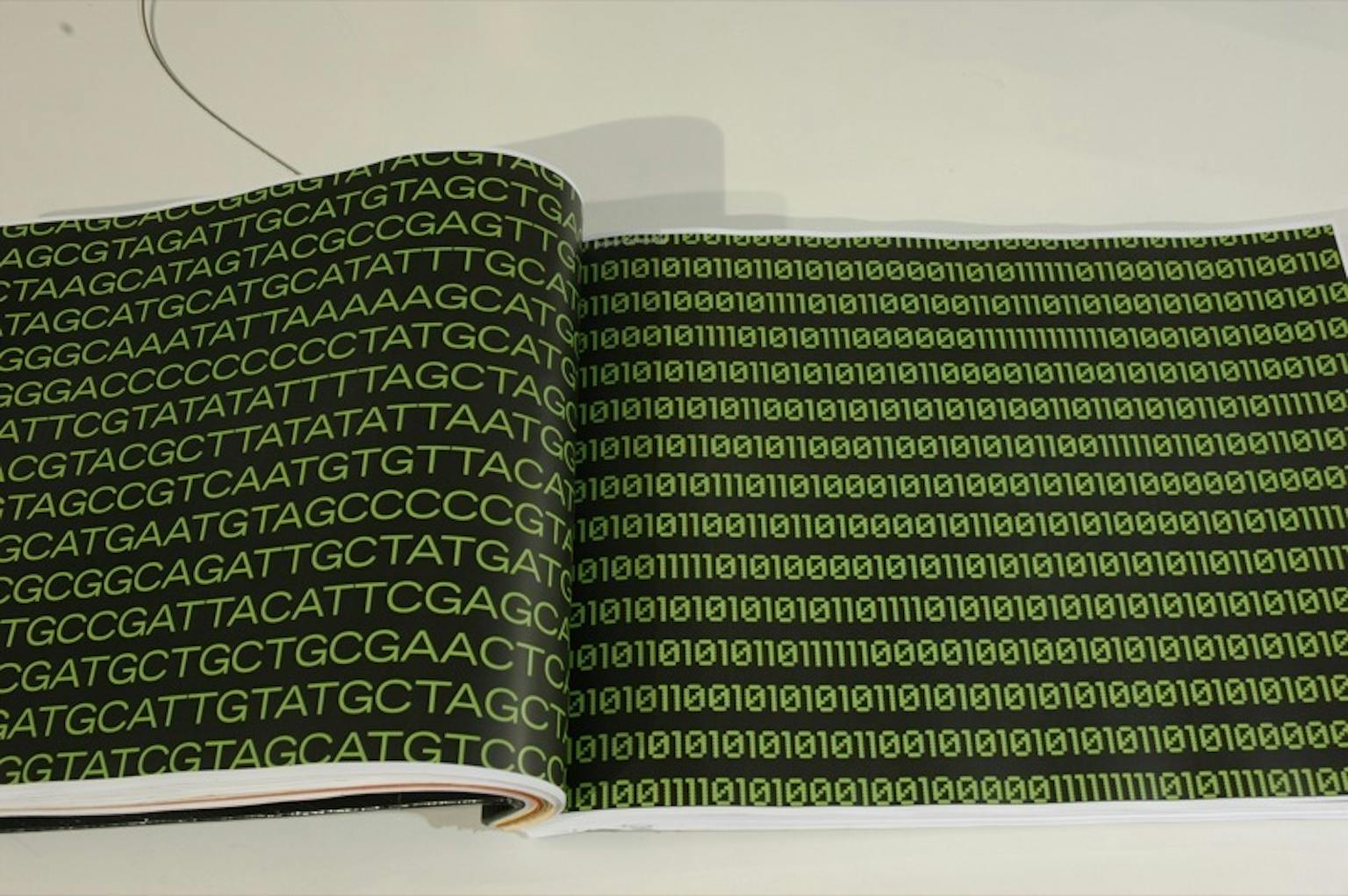 Een zwart boek op een tafel die is opgengeslagen. Op de pagina staan groene letters en cijfers.
