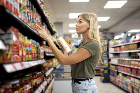 Prijs is voor veel mensen de belangrijkste reden om in de supermarkt wel of niet voor een bepaald product te kiezen. Een vrouw staat voor een schap in de supermarkt met een fles mayonaise in haar had. Met een vinger als leesondersteuning bekijkt ze een product op het schap.