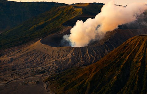 De Bromo is een actieve vulkaan op het eiland Java in Indonesië. Uit een krater van een vulkaan komt een rookwolk.