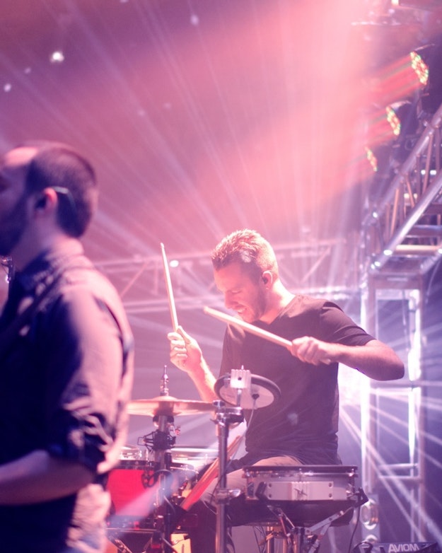 Zijaanzicht van een gitarist en drummer op een podium