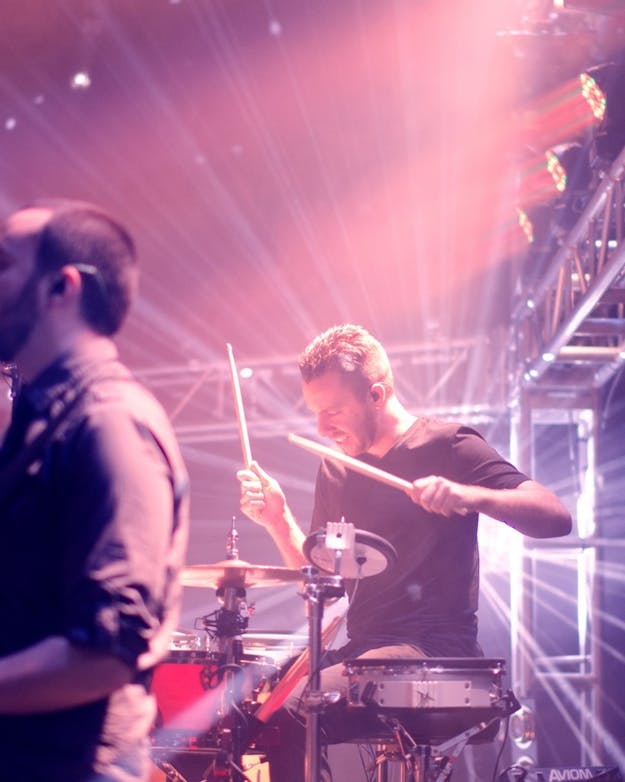 Zijaanzicht van een gitarist en drummer op een podium