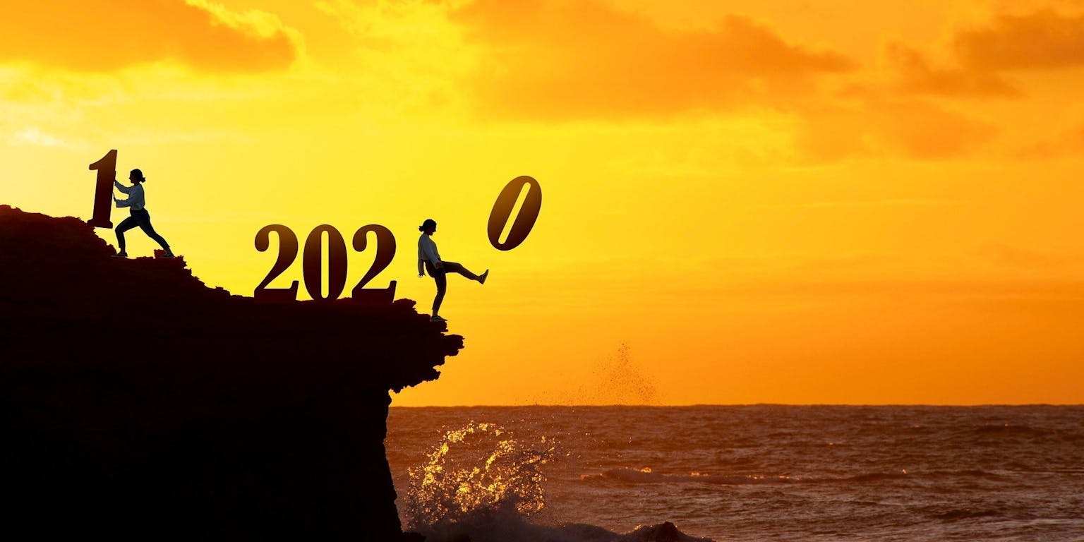 Twee personen bij een klif die de jaarwisseling symboliseren van 2020 naar 2021.
