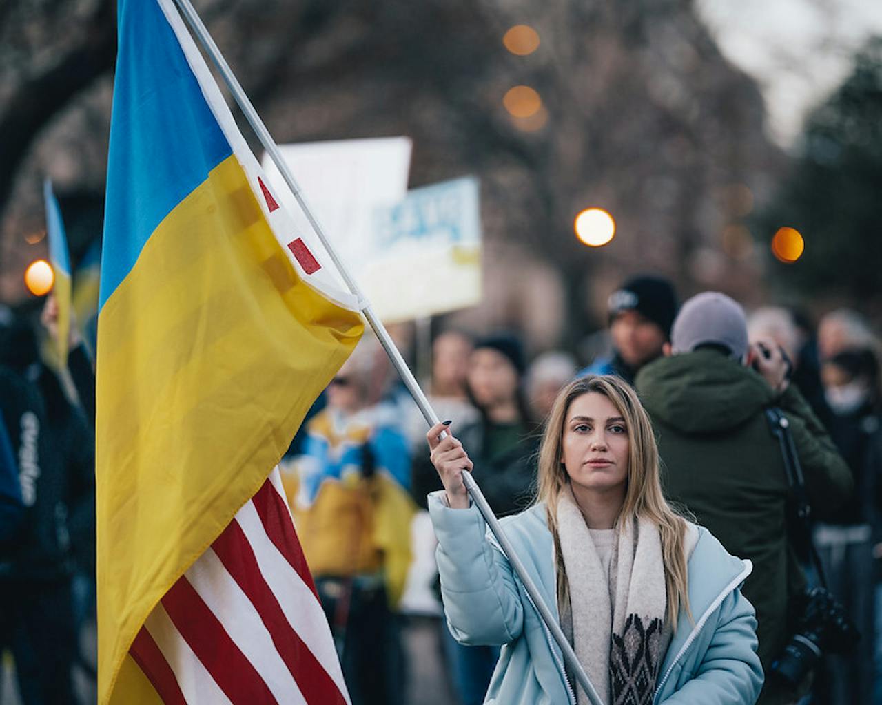 Een vrouw met een Amerikaanse en Oekraïense vlag.