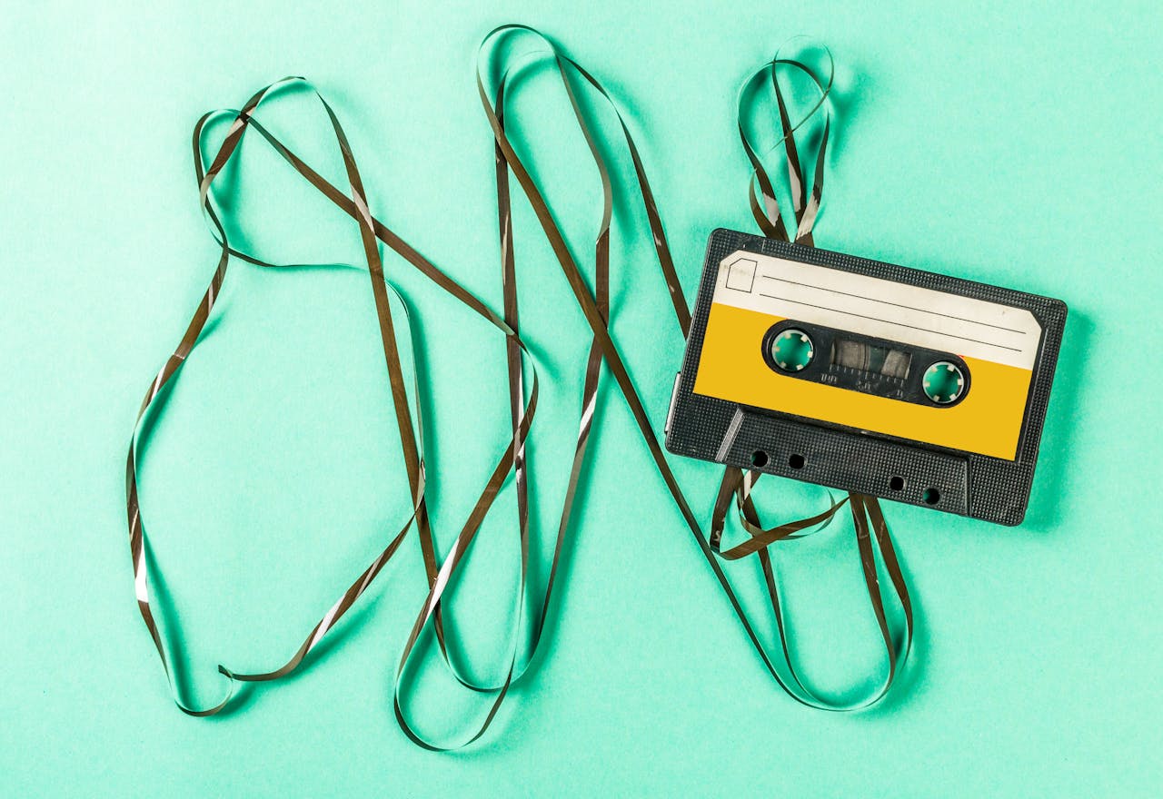 een kapot gedraaid cassettebandje tegen een groene achtergrond