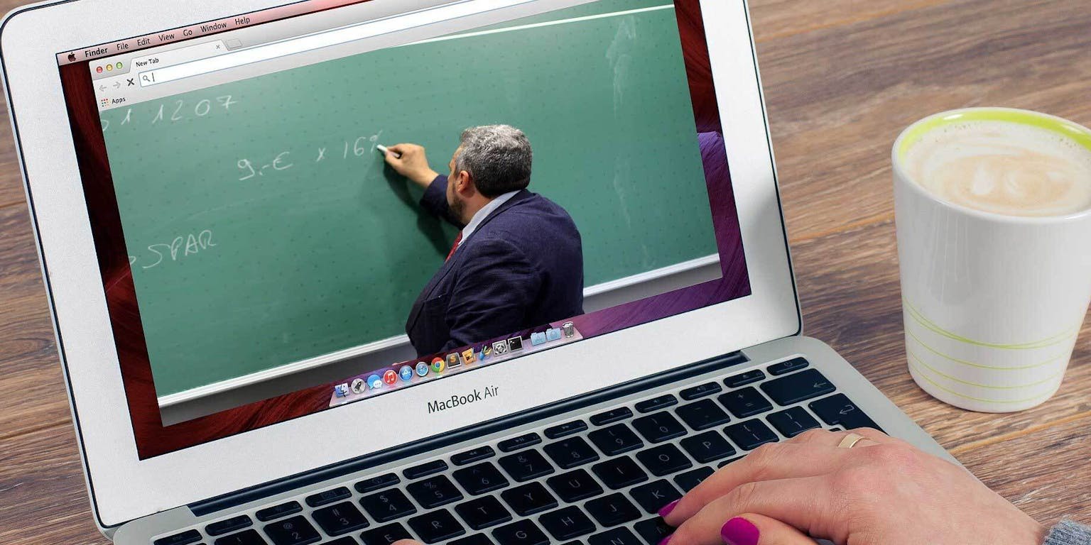 Een persoon die een laptop gebruikt om online een les van school te volgen. Op het beeldscherm is te zien dat er een persoon bij een schoolbord staat.