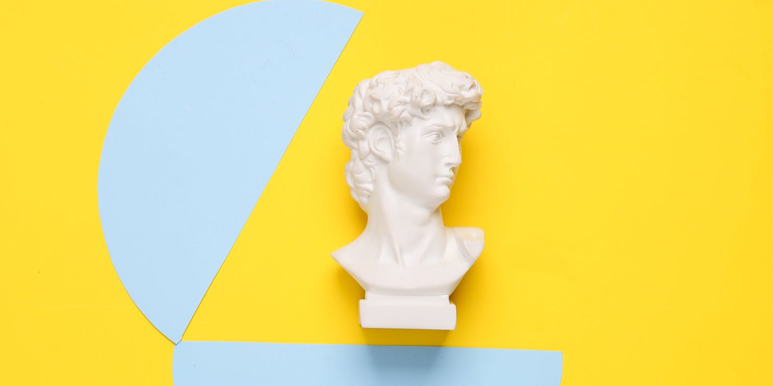 uit een hoofd dat is uitgeknipt uit een blauw vel papier komt een buste van David