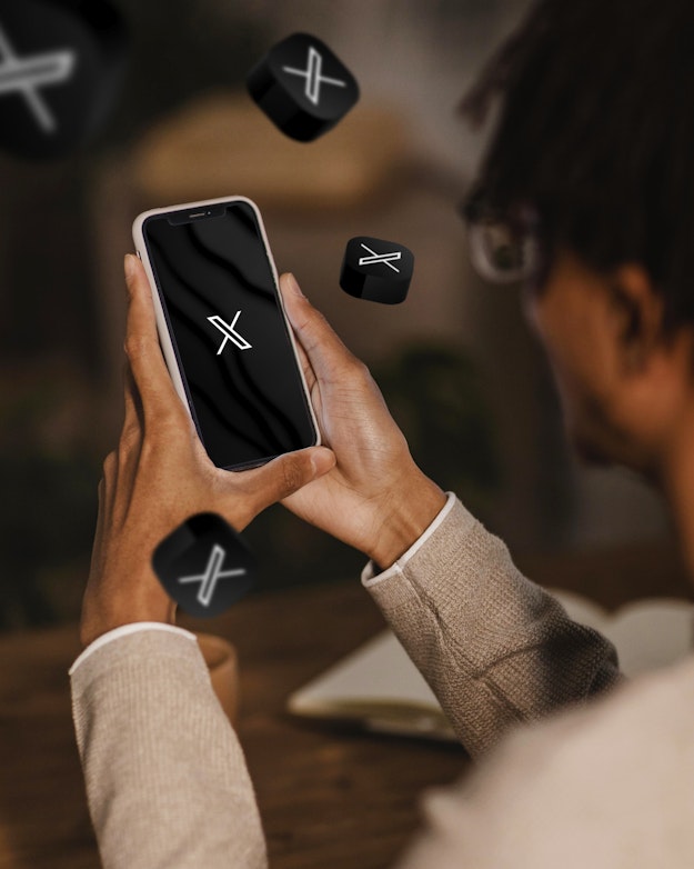 Een man houdt een smartphone vast waarop het logo van socialmediaplatform X is te zien.