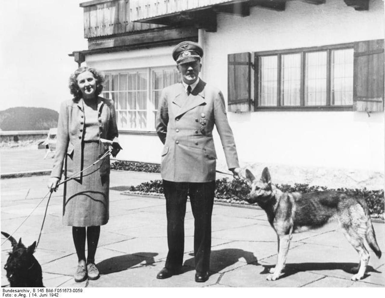 Een zwart-wit foto van Hitler en zijn minnares Eva Braun. Op de foto staat ook hond Blondi.