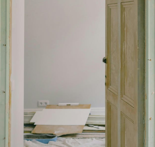 Open deur naar kamer met verhuismateriaal op de vloer. Open deur naar kamer met verhuismateriaal op de vloer.
