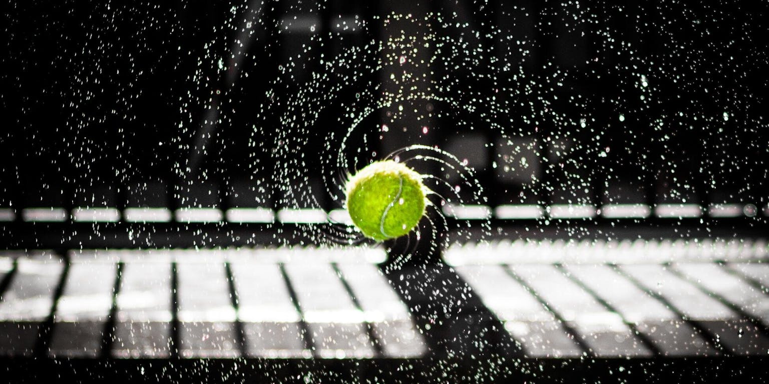 Een afbeelding van een tennisbal met opspattend water.
