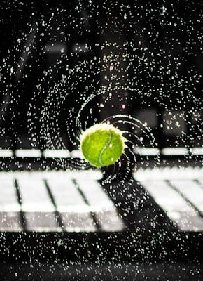 Een afbeelding van een tennisbal met opspattend water.