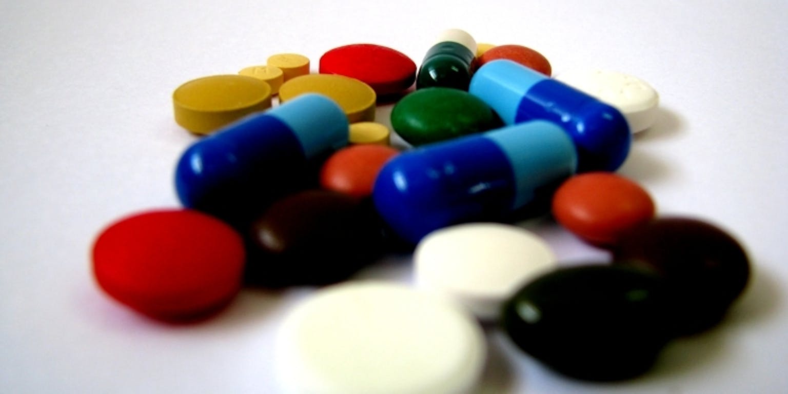Een stapel verschillende gekleurde pillen op een wit oppervlak.
