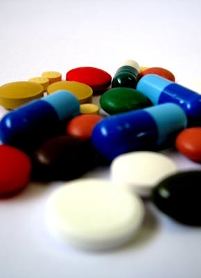 Een stapel verschillende gekleurde pillen op een wit oppervlak.