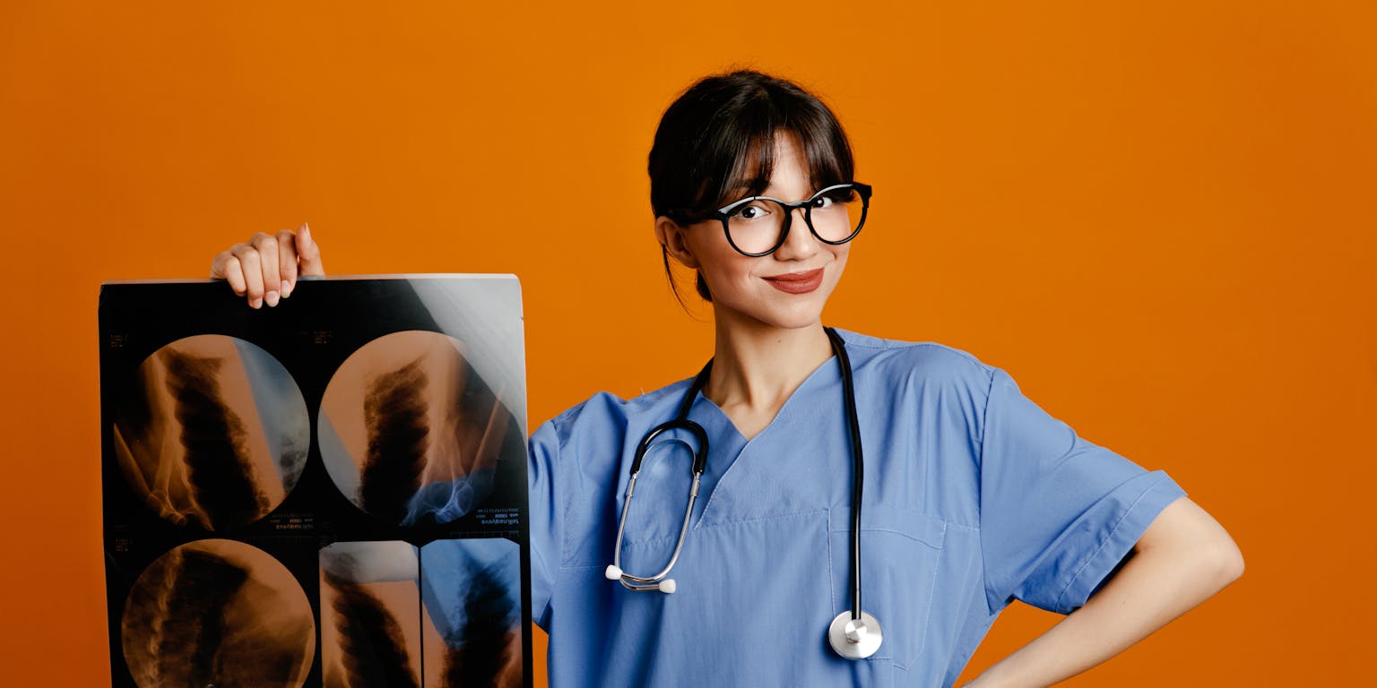 jonge arts houdt rontgenfoto vast tegen een oranje achtergrond