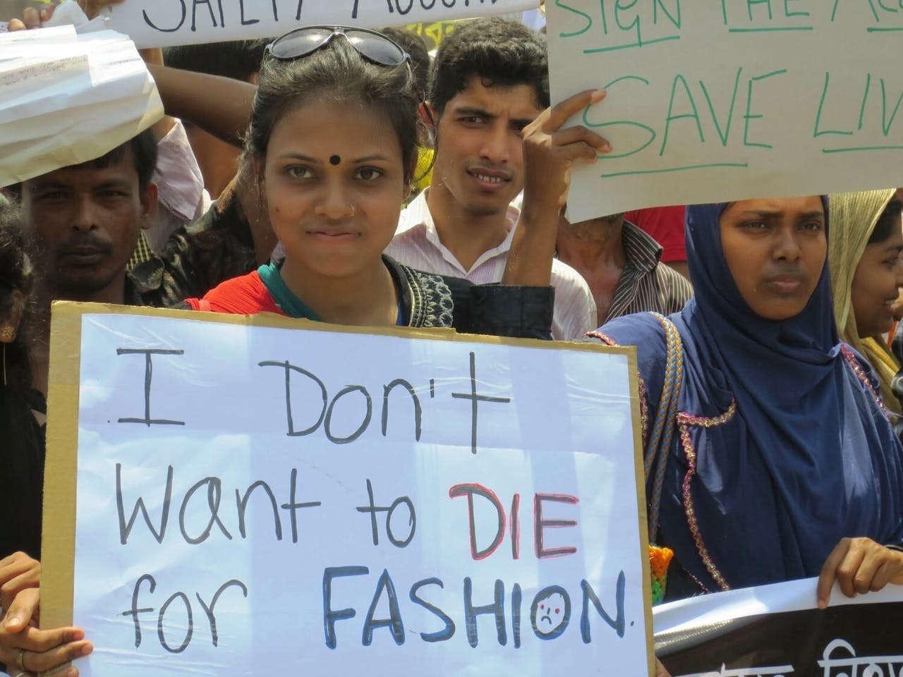 Een groep arbeiders protesteert tegen de kledingindustrie. Op hun bord staat de tekst 'I don't want to die for fashion'.