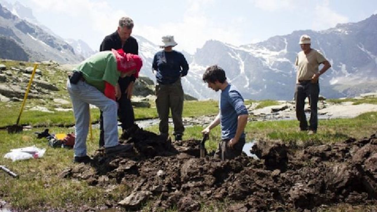 Een groep mensen die in de bergen aan het graven zijn. Ze onderzoeken poep.