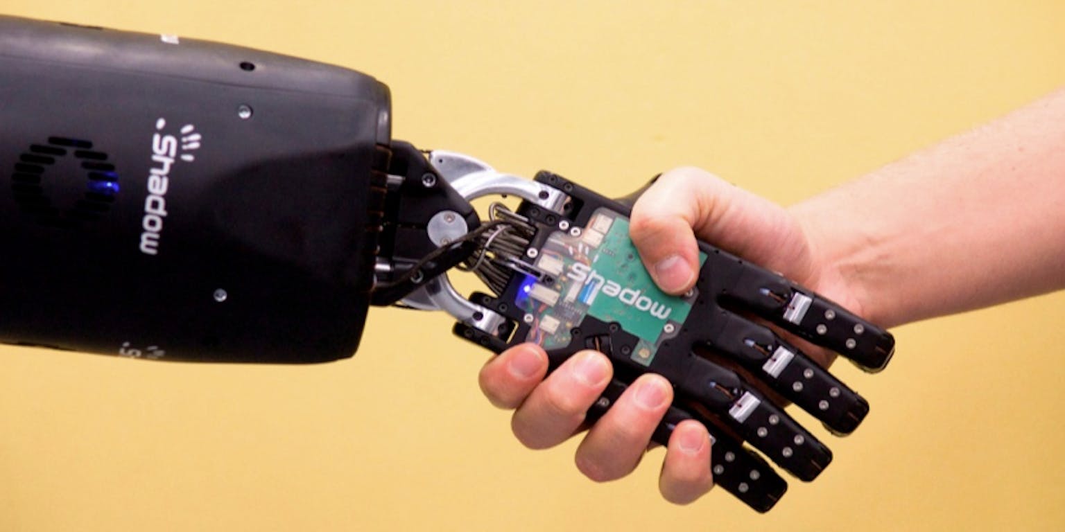 Een robothand wordt vastgehouden door een persoon.