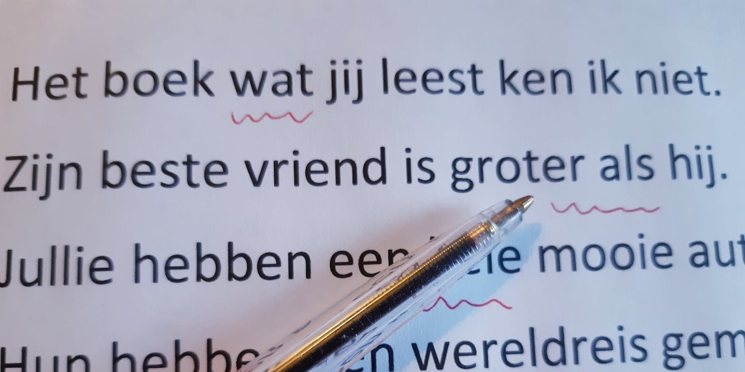 Op een vel papier ligt een rode pen waarmee fouten in de tekst zijn onderstreept.