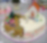 Een gebroken hartvormige taart. De scheiding is te herkennen door het gebruik van twee verschillende kleuren. Op de taart staat een huis, een tent en twee figuren.