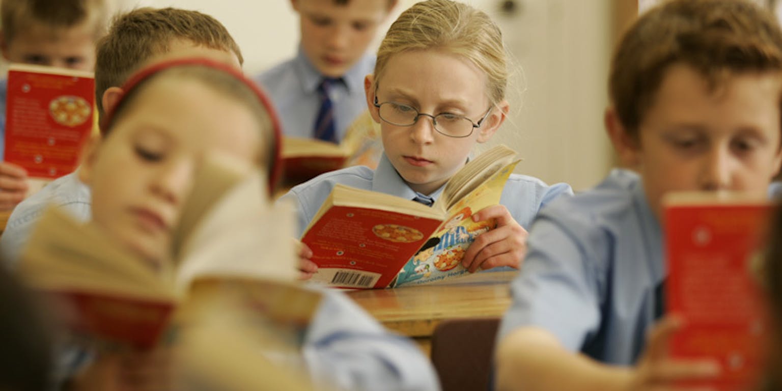 Een groep kinderen die boeken lezen in een klaslokaal.