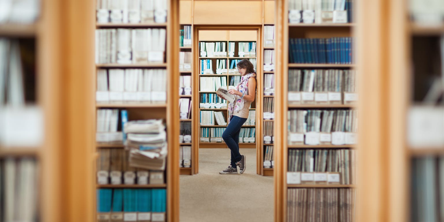 Lezende vrouw in bibliotheek