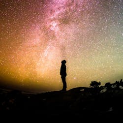 Man kijkt omhoog naar een sterrenhemel