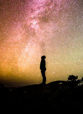 Man kijkt omhoog naar een sterrenhemel